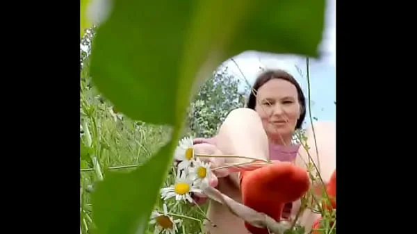 Naked horny MILF in a chamomile field masturbates, pisses and wards off a wasp / Angela-MILF